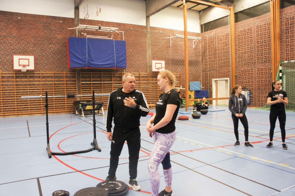 Tränaren Peter pratar med Matilda om hur hon kan instruera besökarna.